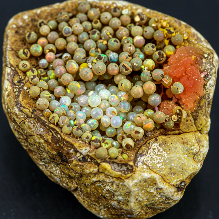 Ópalos "guisante" en matriz Cavidad de roca con una concentración de ópalos en forma de "guisante" (ópalos bola) de colores variados.